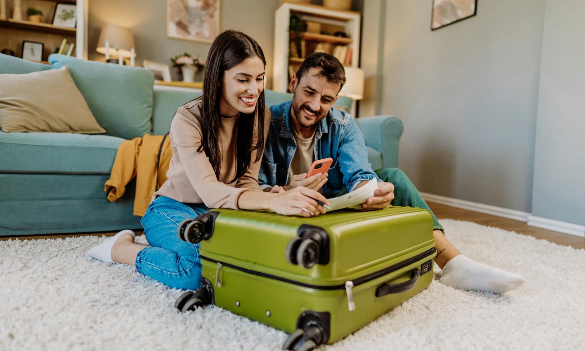 A couple looking at a phone while packing