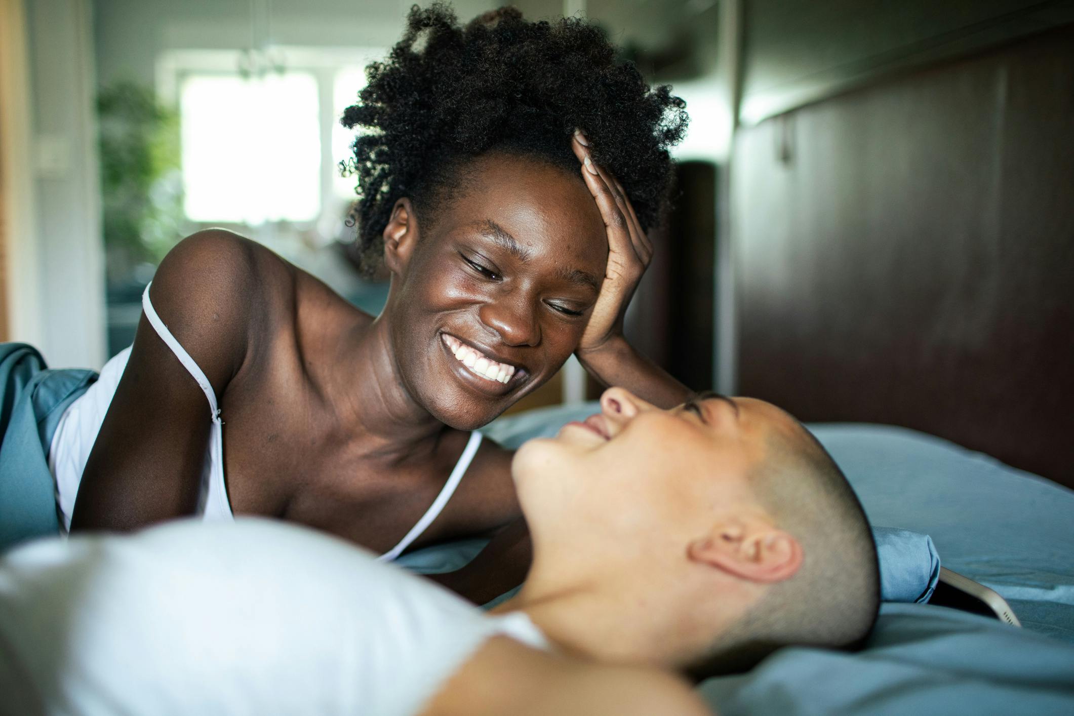 woman looking at another woman in bed