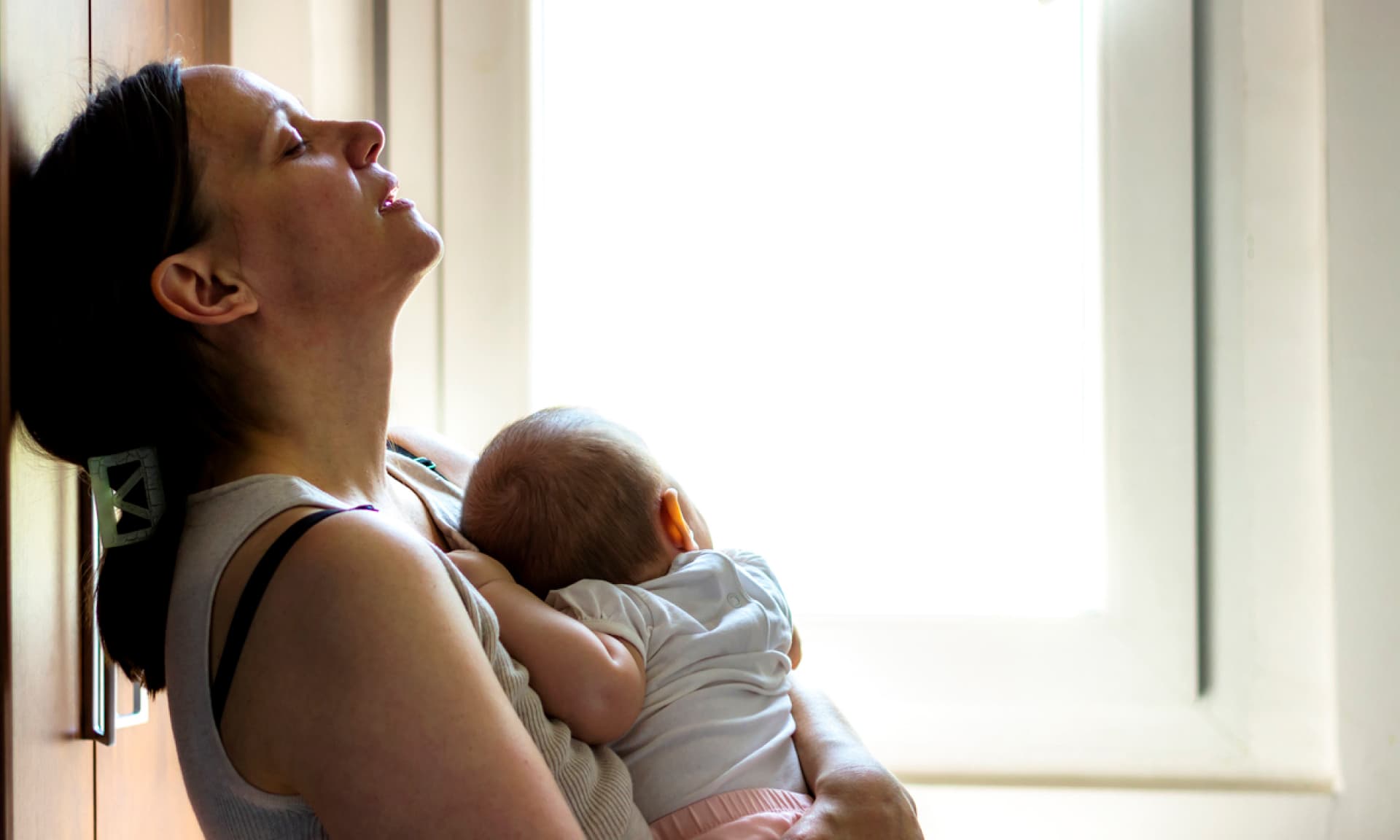 A woman shaking pills into her hand in the bathroom
